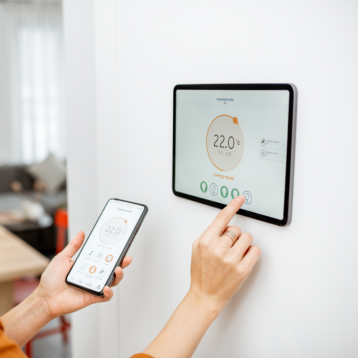 FGV Impianti Biella S.R.L. Domotica Gestione domotica tramite smartphone e pannello a parete.
Persona che utilizza uno smartphone per controllare un pannello domotico montato su parete bianca. Il display digitale mostra dati sulla temperatura e sul consumo energetico. L’ambiente è moderno e luminoso, con cablaggi elettrici nascosti.
